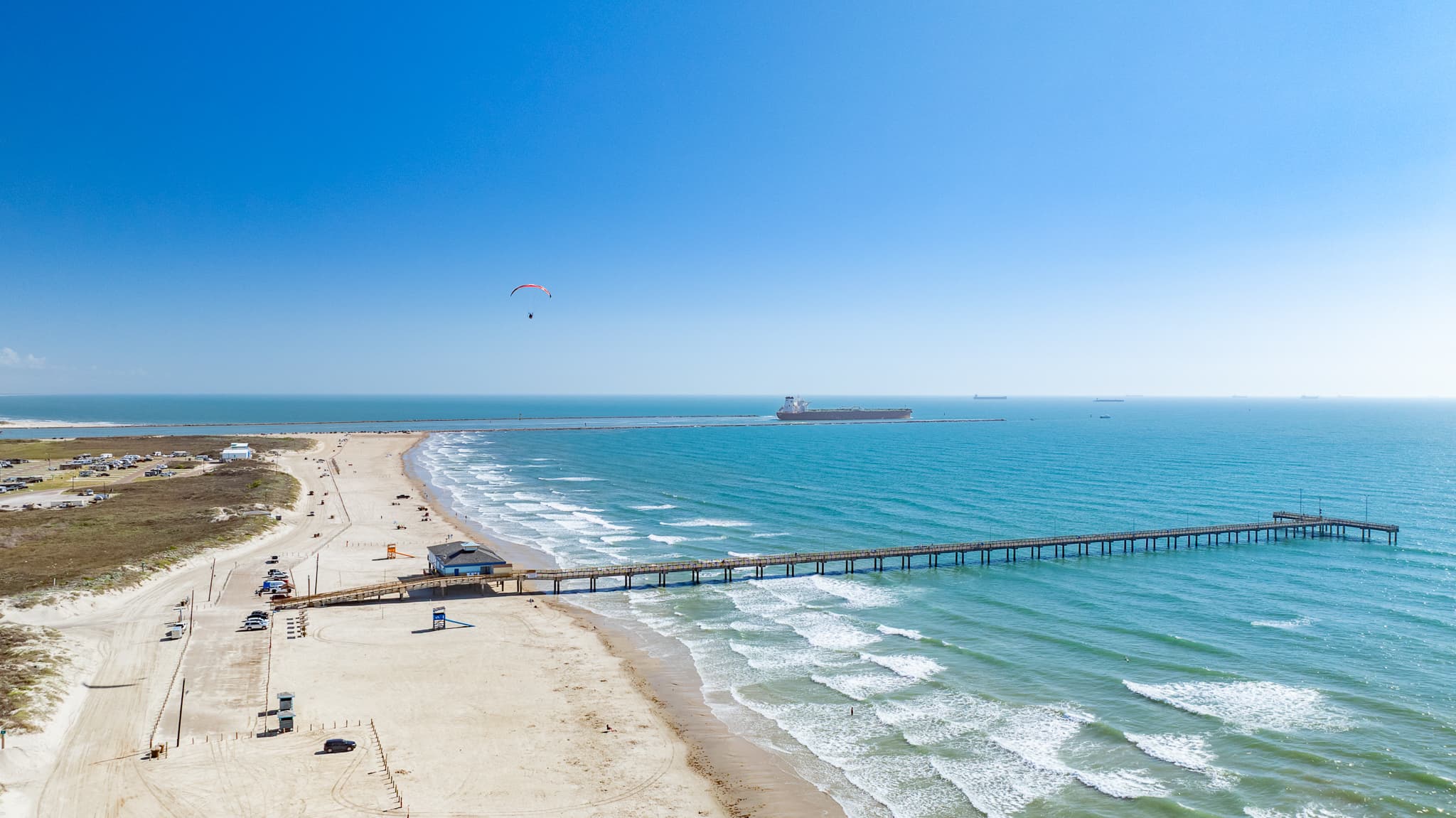 Aerial of Port Aransas beach, Gulf surf, and Horace Caldwell Pier
