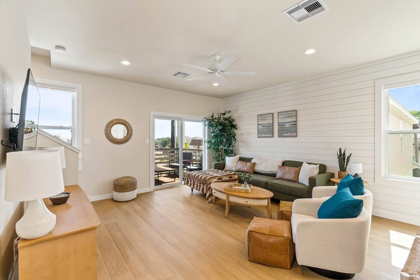 Additional view of the inviting living room with cozy sectional, smart TV, and direct access to the balcony, perfect for taking in the sea air.