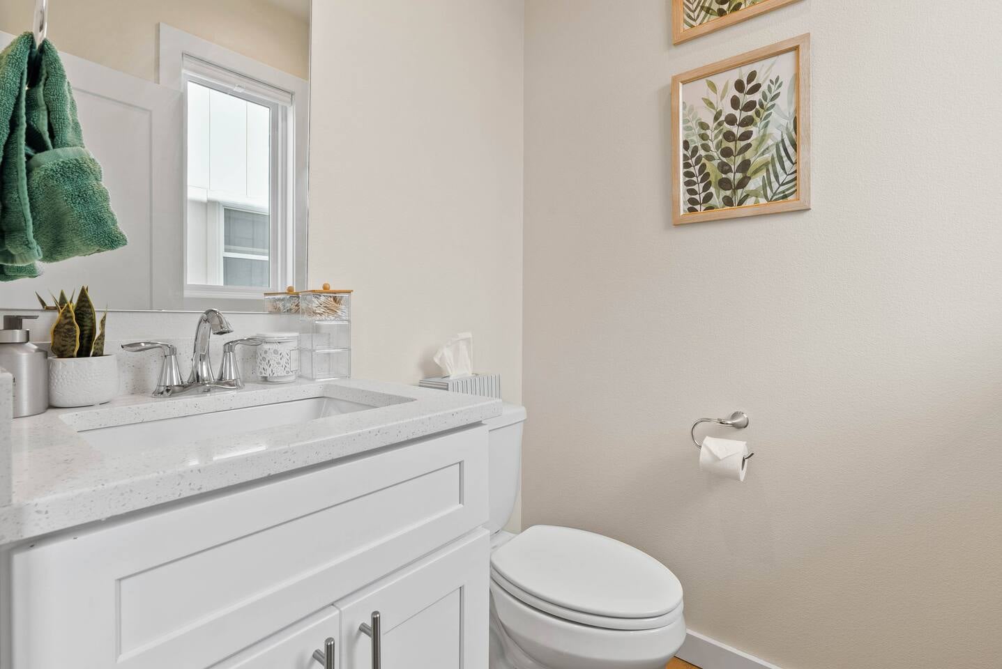 Bright, modern second-floor powder room conveniently located near the kitchen and living room, stocked with essentials.