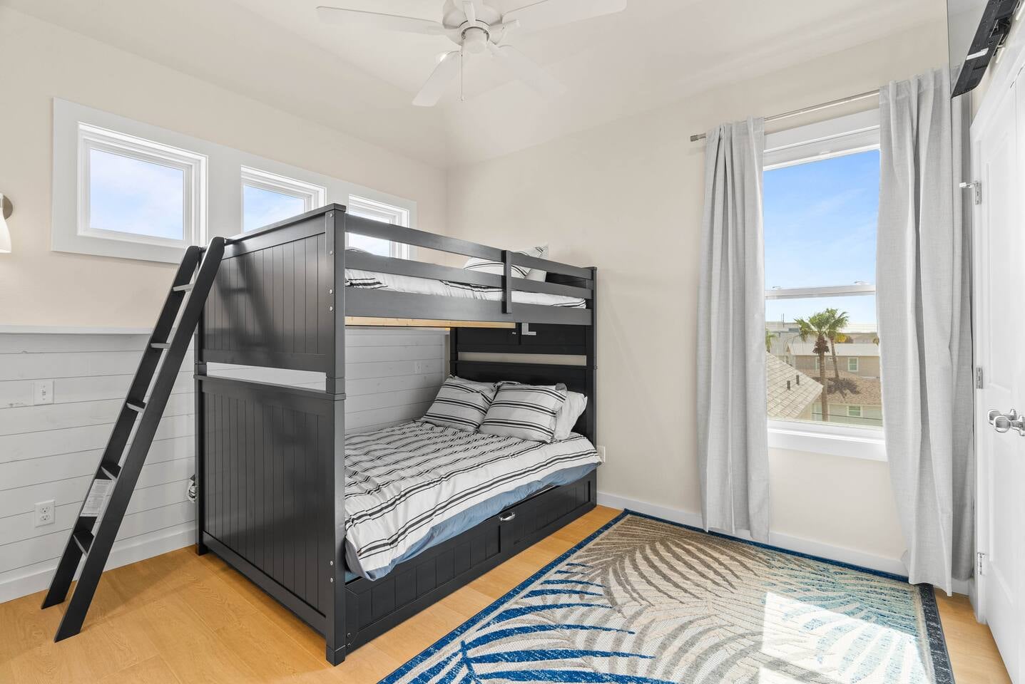 3rd-floor bunk room with two full-size beds and a twin trundle, perfect for families or kids, with natural light and views. Conveniently located near the master bedroom and features smart TV an ensui