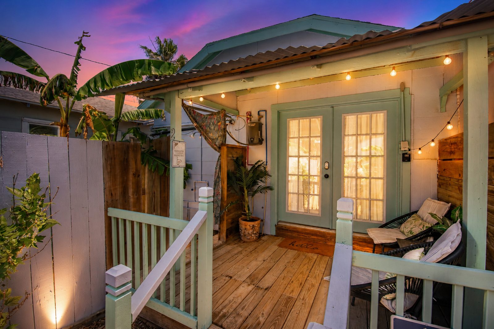 Anglers Court cottage porch with string lights at sunset